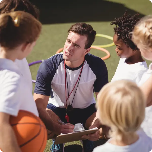 Coach holding trophy and soccer ball